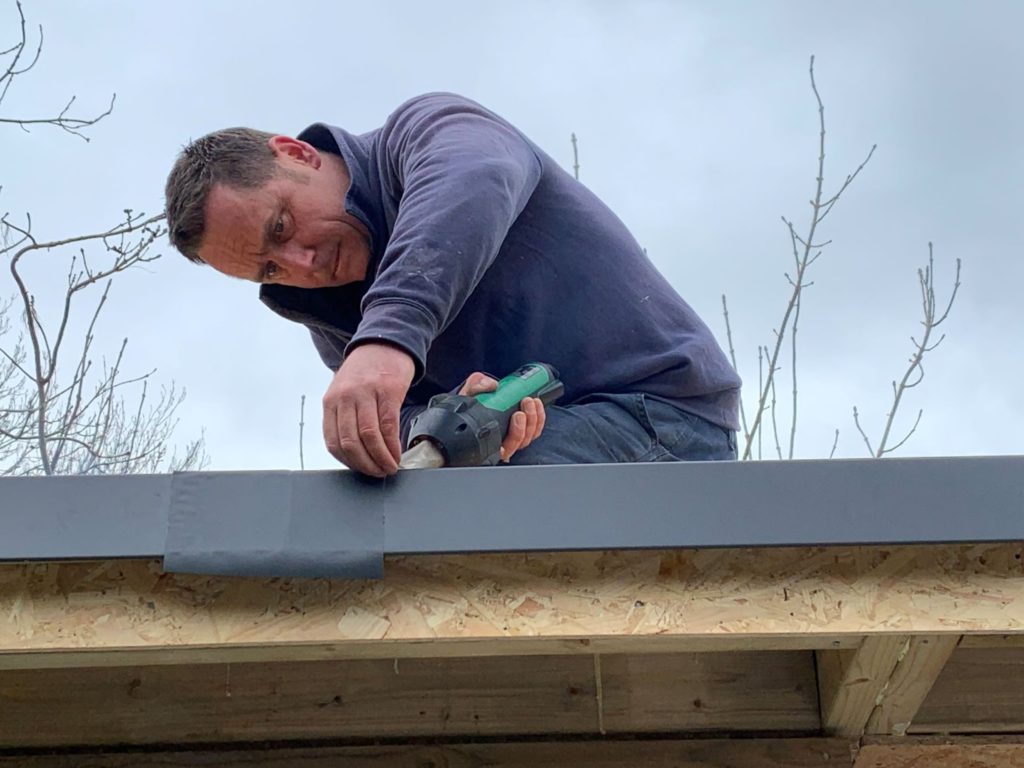 Roof being fitted on a garden building